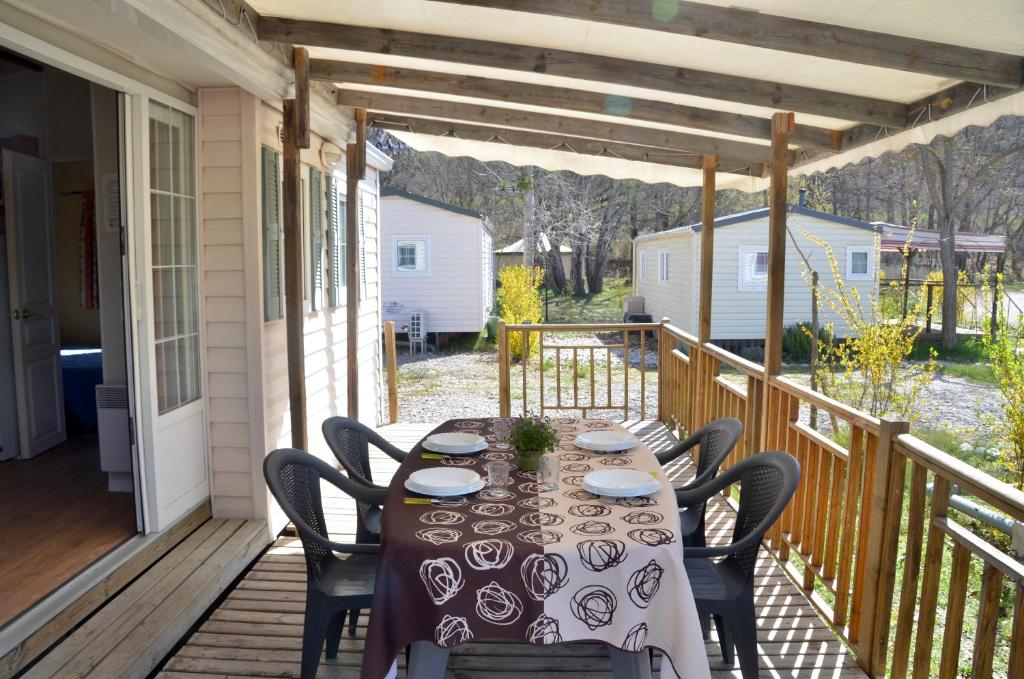 une table sur le porche d'une maison dans l'établissement Camping Tikayan La Célestine, à Beynes