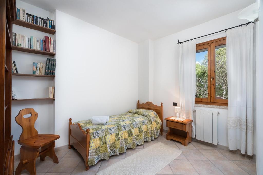 une chambre avec un lit, une fenêtre et une chaise dans l'établissement Sardinia Family Villas - Villa Adina with private pool in Arzachena, à Arzachena 48 autres photos