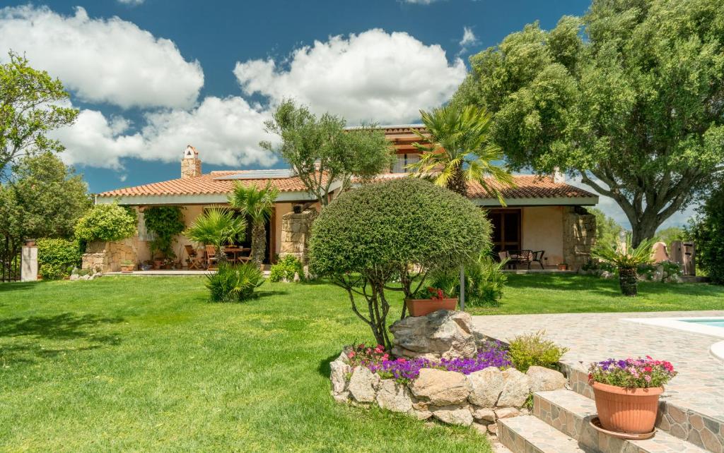 une maison avec un jardin devant dans l'établissement Sardinia Family Villas - Villa Adina with private pool in Arzachena, à Arzachena