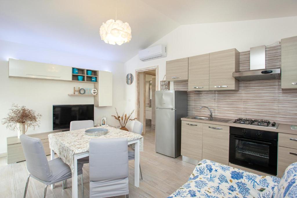 une cuisine et une salle à manger avec une table et des chaises dans l'établissement Oasi del relax, à Budoni