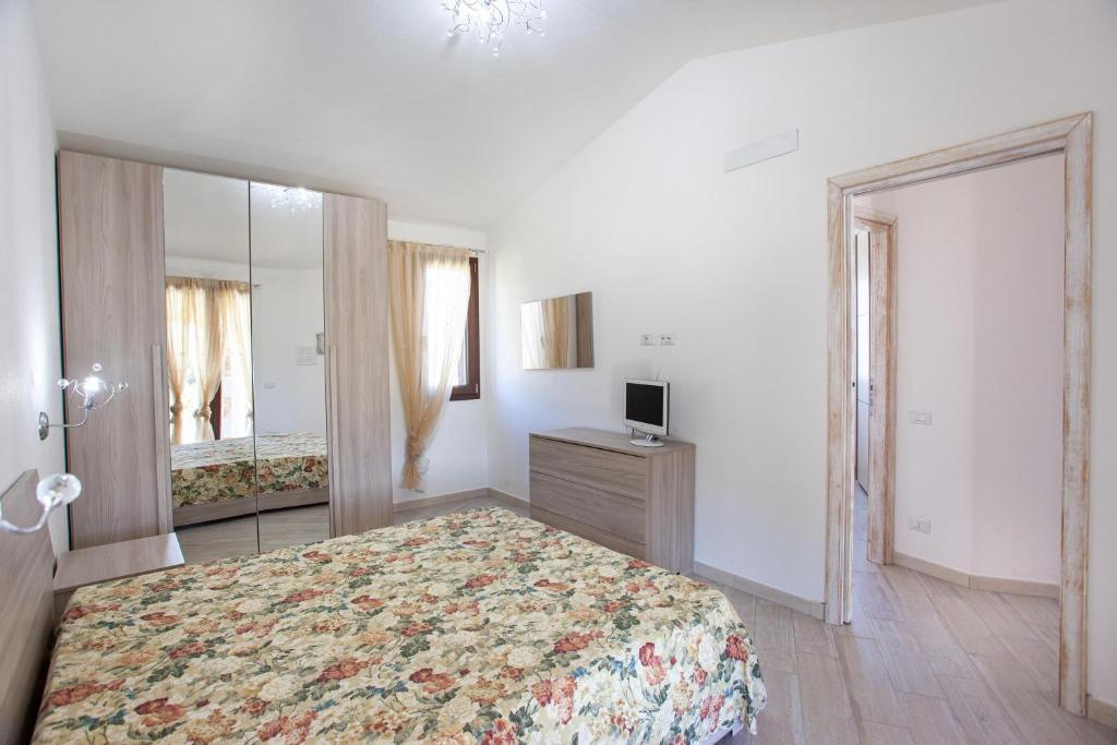 une chambre avec un grand lit et un miroir dans l'établissement Oasi del relax, à Budoni