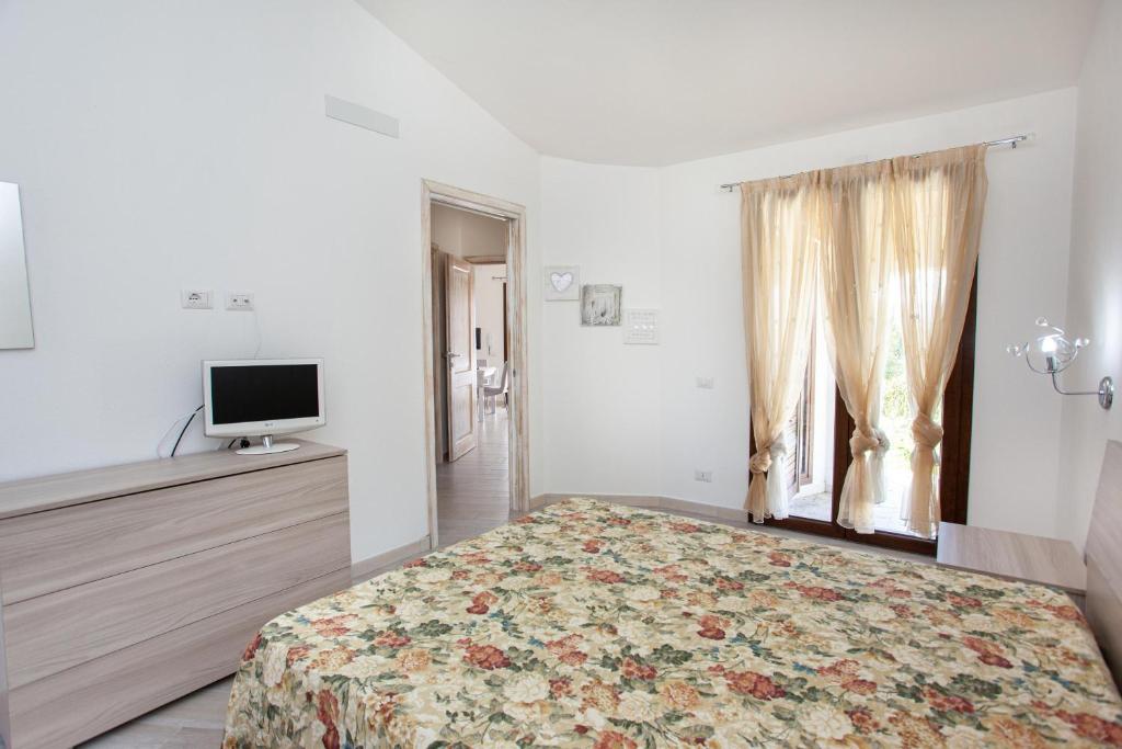 une chambre avec un lit, une télévision et une fenêtre dans l'établissement Oasi del relax, à Budoni 25 autres photos