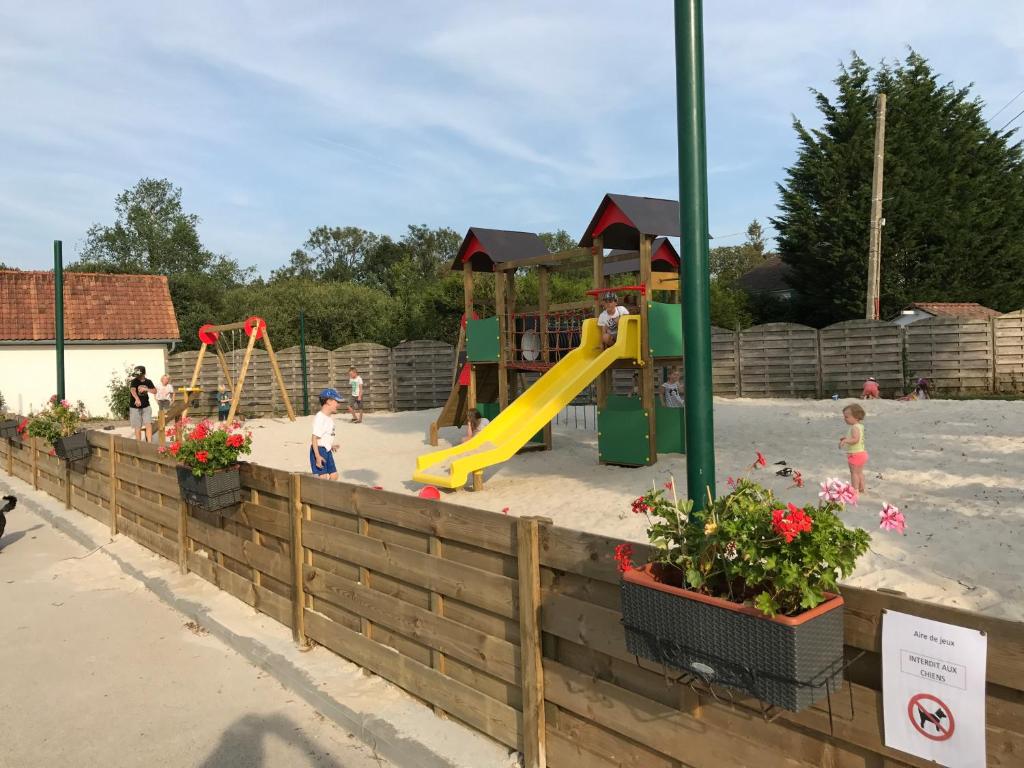 une aire de jeux avec toboggan et matériel de jeux dans l'établissement Camping La Garenne De Moncourt, à Rue