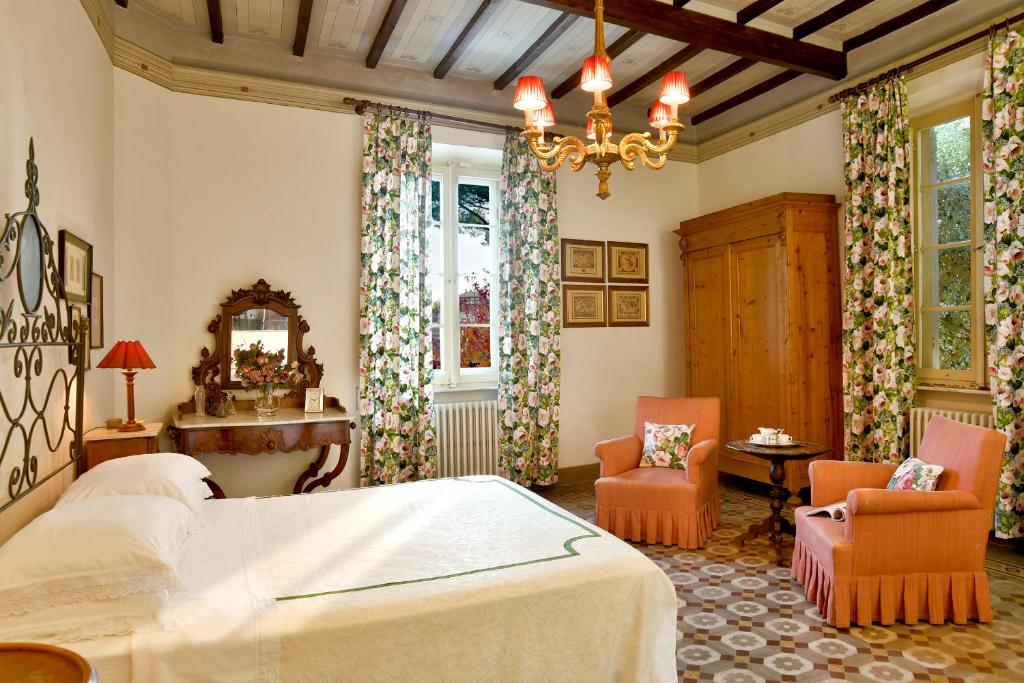 une chambre avec un lit et deux chaises dans l'établissement Villa Carlotta con piscina, à Lari 47 autres photos