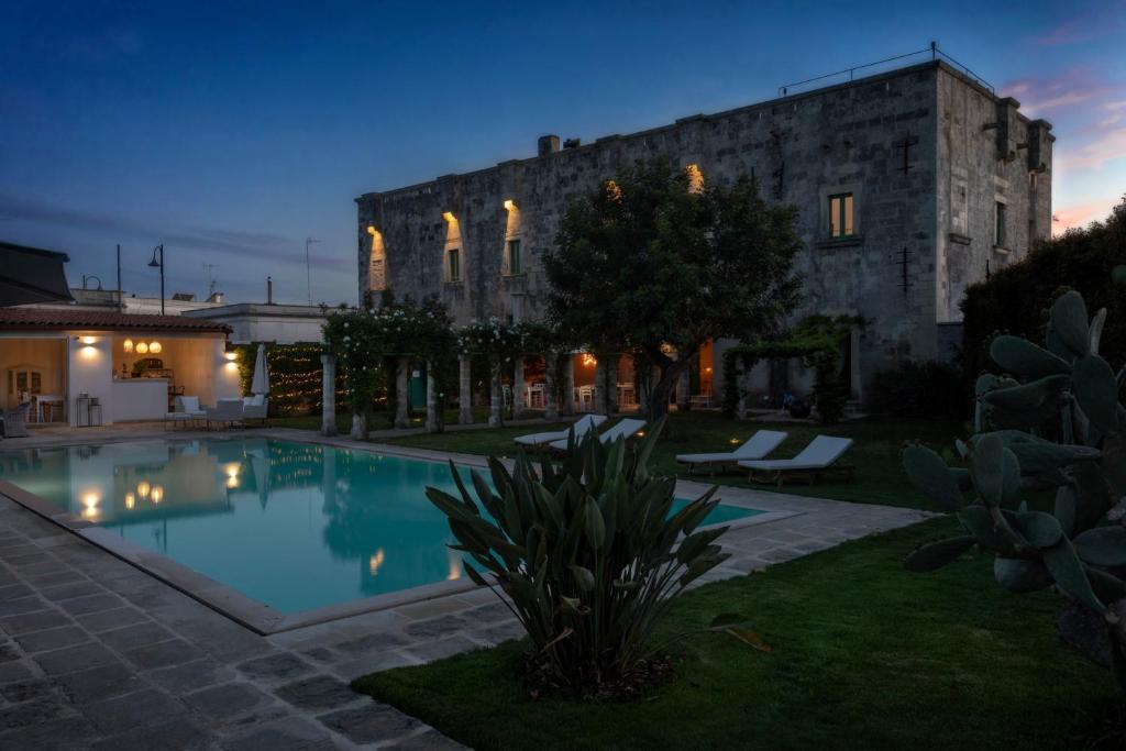 une maison avec piscine devant un immeuble dans l'établissement Palazzo Ducale Venturi - Luxury Hotel & Wellness, à Minervino di Lecce