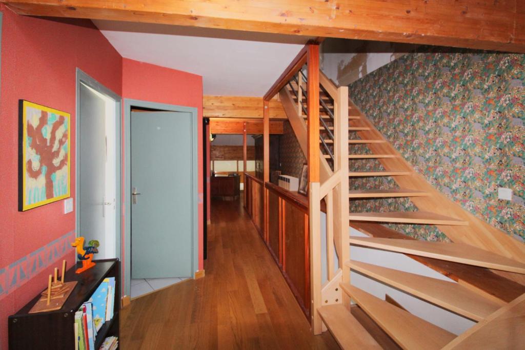 - un escalier dans une pièce aux murs rouges dans l'établissement Gîte comme à la maison -12 pers- La Cabiote, à Les Piards