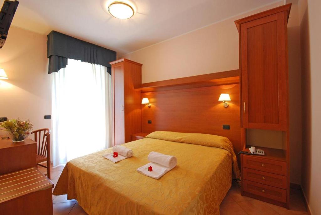 une chambre avec un lit avec deux serviettes dessus dans l'établissement Hotel Jole, à Cesenatico