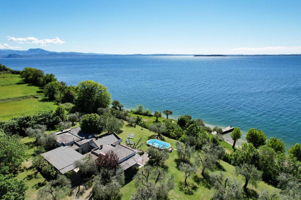 une vue aérienne sur une maison à côté de l'eau dans l'établissement Casa Raffaella -Ciao Vacanze-, à Moniga del Garda