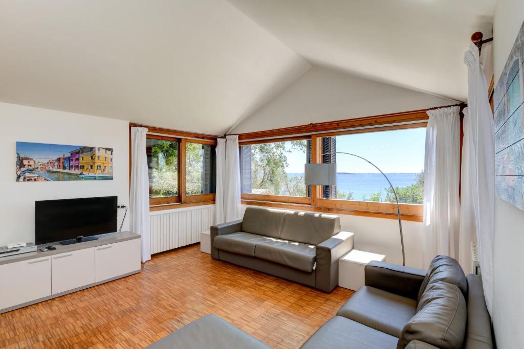 un salon avec un canapé et une télévision dans l'établissement Casa Raffaella -Ciao Vacanze-, à Moniga del Garda