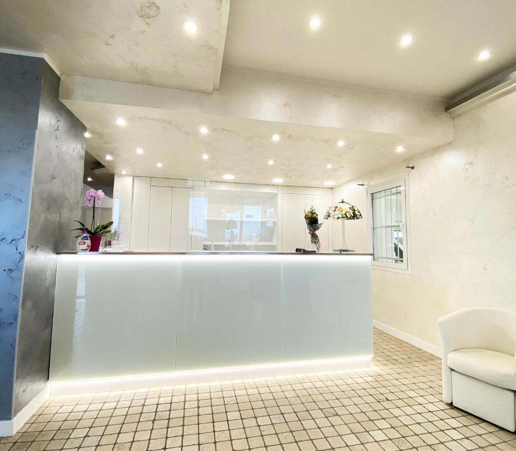 - un hall avec un grand comptoir blanc dans l'établissement Hotel Linda, à Caorle