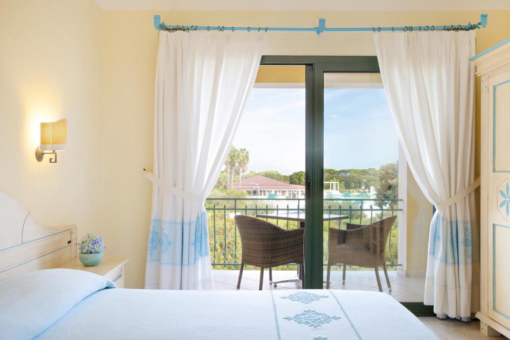 une chambre avec un lit et un balcon dans l'établissement Club Hotel Marina Beach, à Orosei