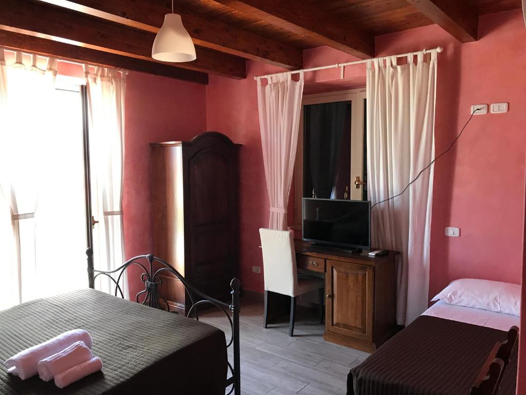 - une chambre avec un lit, une télévision et un bureau dans l'établissement Villa Scotillo Boutique Hotel, à Agropoli