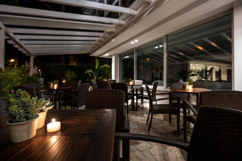 un restaurant avec des tables, des chaises et une bougie dans l'établissement Hotel Pacific, à Riccione