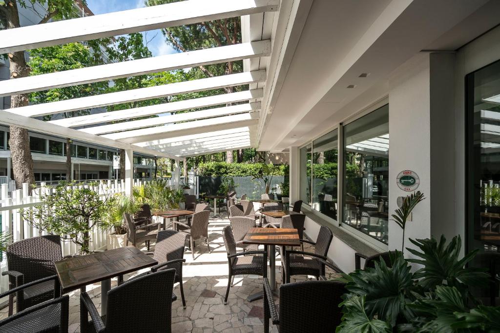 un patio extérieur avec tables, chaises et fenêtres dans l'établissement Hotel Pacific, à Riccione