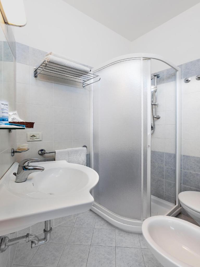 une salle de bain avec douche, lavabo et toilettes dans l'établissement Hotel Pacific, à Riccione