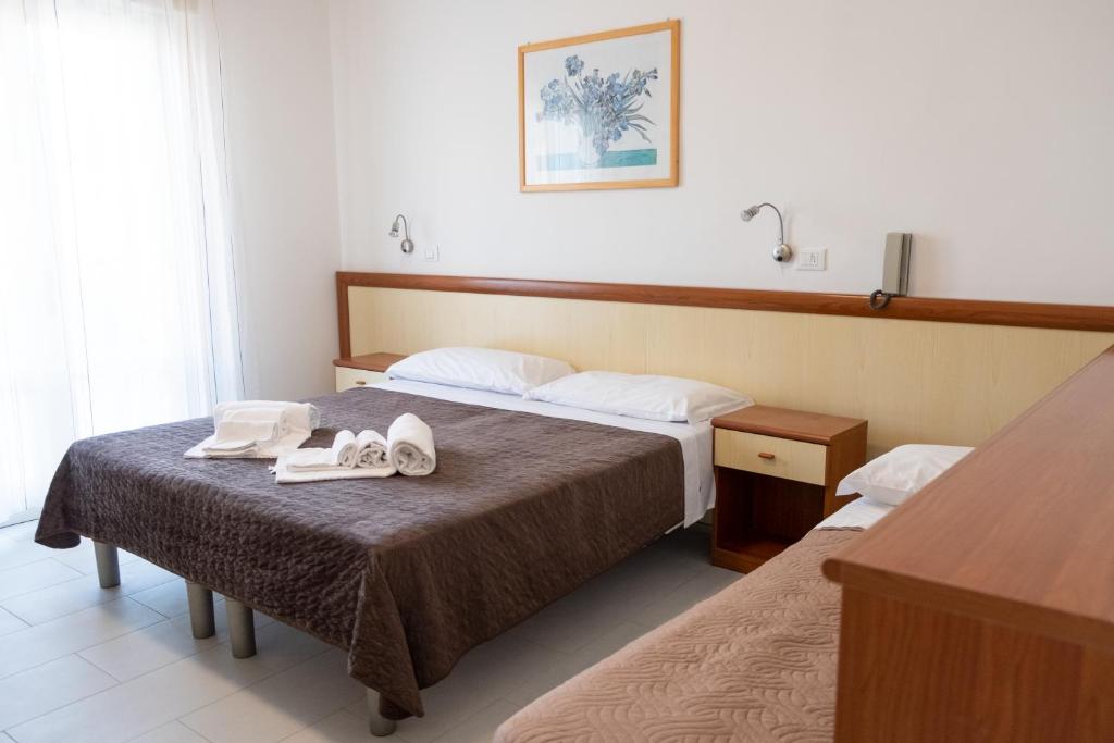 une chambre d'hôtel avec deux lits avec des serviettes sur le lit dans l'établissement Hotel Esperia, à Caorle 32 autres photos