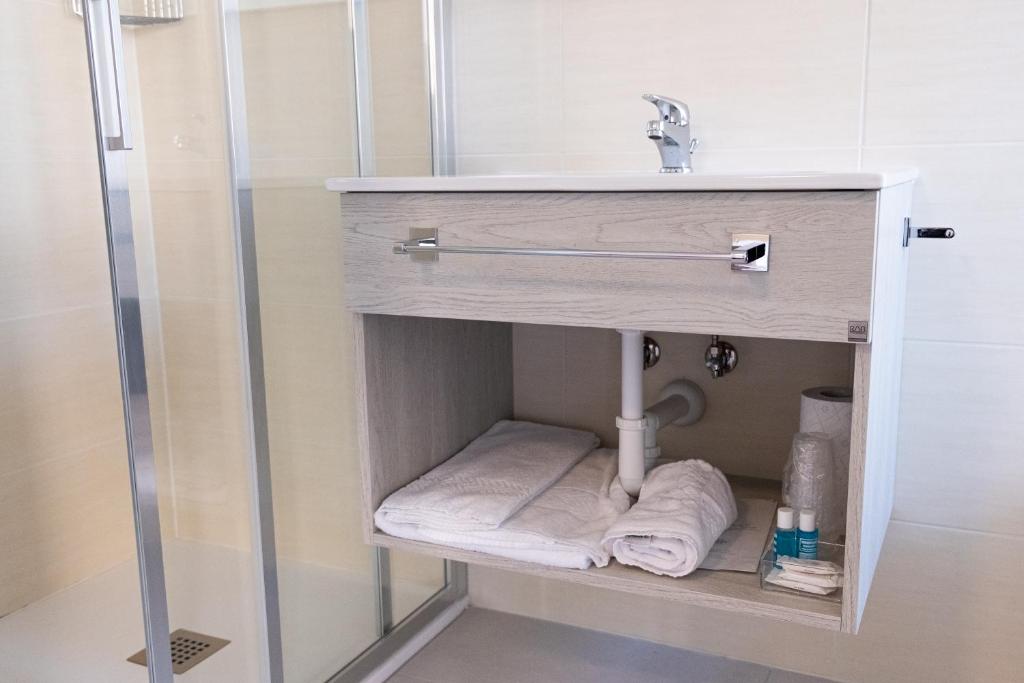 La salle de bains est pourvue d'un lavabo et d'un porte-serviettes. dans l'établissement Hotel Esperia, à Caorle