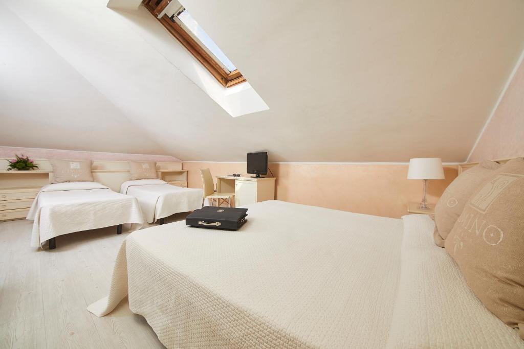 - une chambre avec 2 lits avec des draps blancs et une valise dans l'établissement Hotel Vienna Ostenda e Ristorante il Danubio, à Rimini 87 autres photos