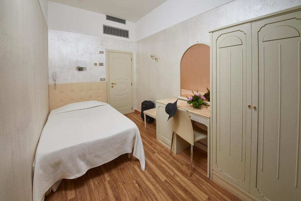 une petite chambre avec un lit et un bureau dans l'établissement Hotel Vienna Ostenda e Ristorante il Danubio, à Rimini