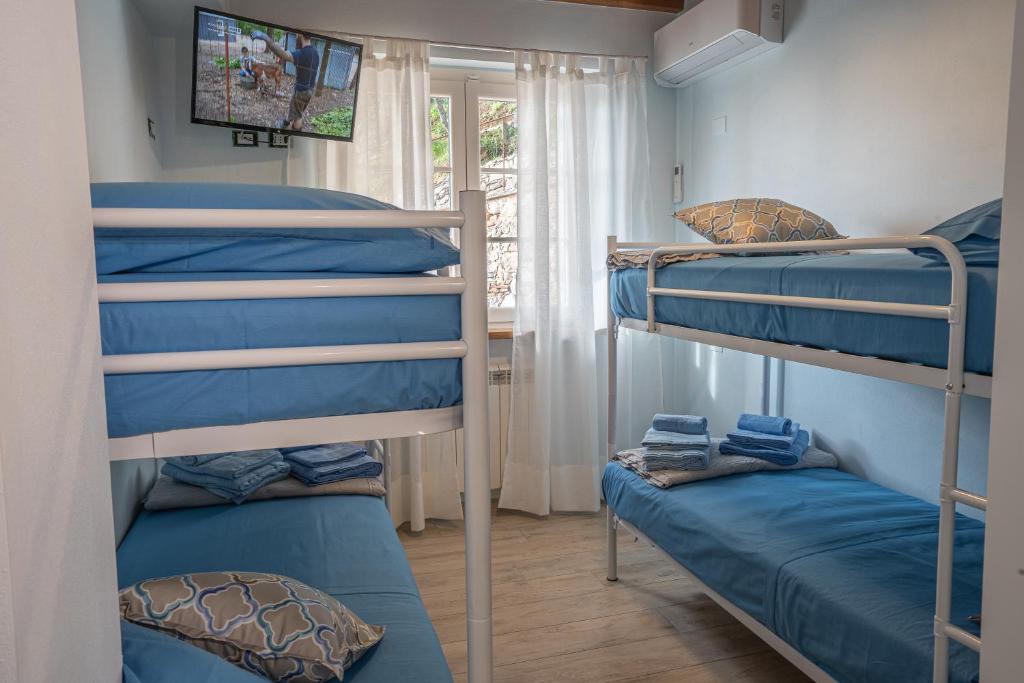 une chambre avec trois lits superposés et une fenêtre dans l'établissement Villa "Il Grillo" Piscina privata, Panorama e privacy, à Camaiore 39 autres photos