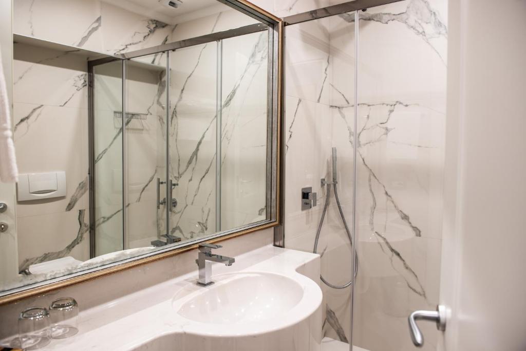 une salle de bain blanche avec un lavabo et un miroir dans l'établissement Hotel Ghiffa, à Ghiffa