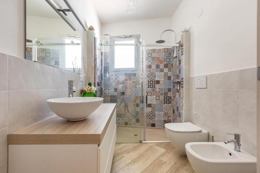 une salle de bain avec un lavabo, des toilettes et une douche dans l'établissement Villa Il Neto by BarbarHouse, à Casarano