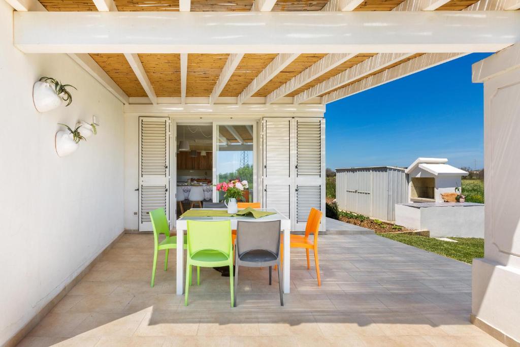une salle à manger avec une table et des chaises sur un patio dans l'établissement Villa Il Neto by BarbarHouse, à Casarano