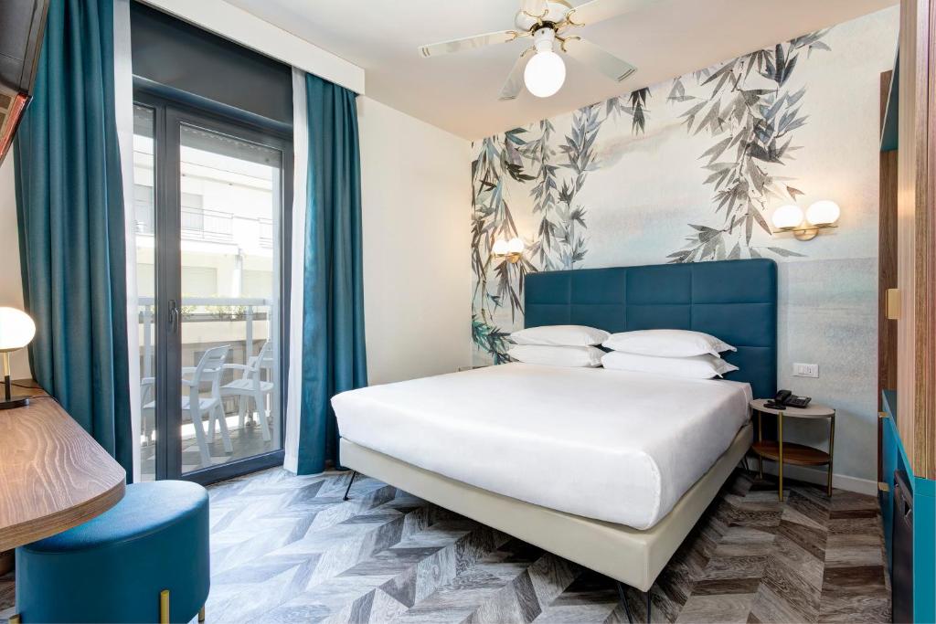 une chambre avec un lit et une grande fenêtre dans l'établissement Hotel Byron Bellavista, à Lido di Jesolo