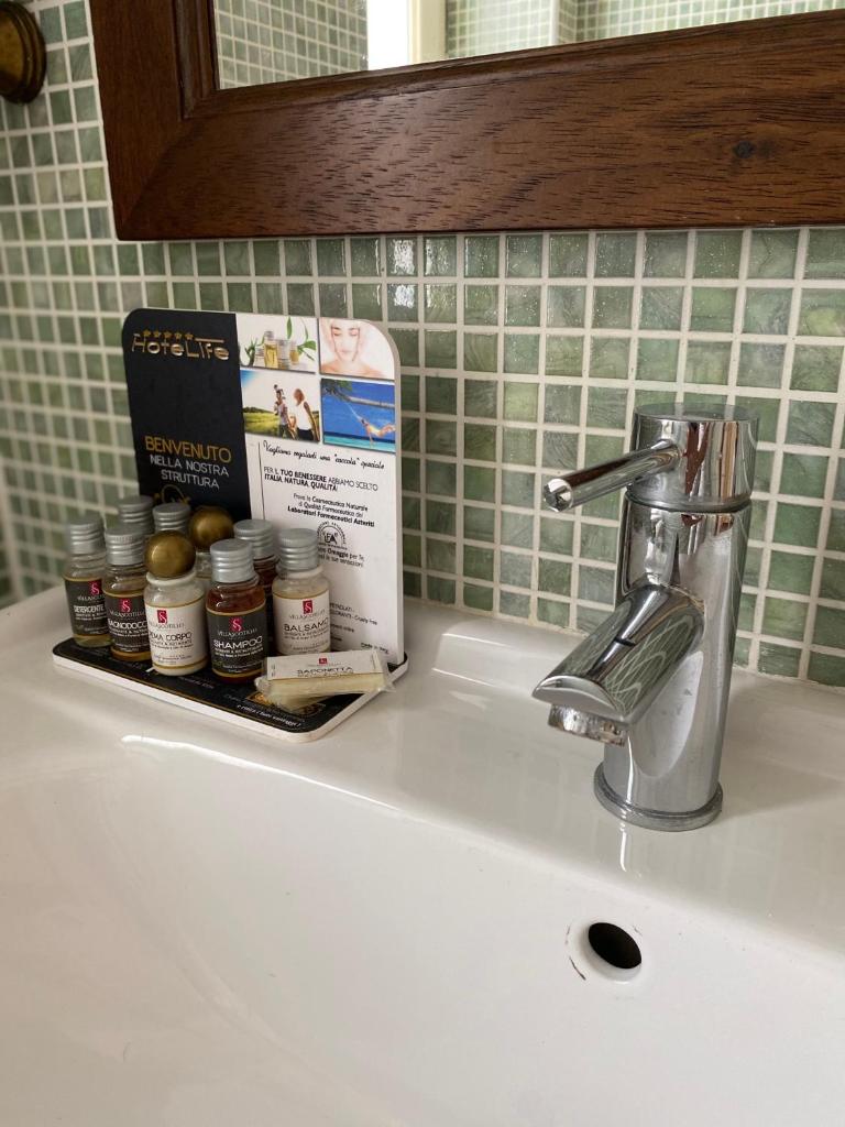 - un évier de cuisine avec un porte-brosse à dents sur le évier dans l'établissement Villa Scotillo Boutique Hotel, à Agropoli