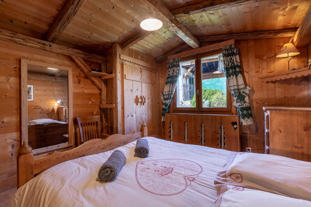 une chambre avec un lit dans une cabane en rondins dans l'établissement Chalet Quatre Saisons, à Saint-Gervais-les-Bains
