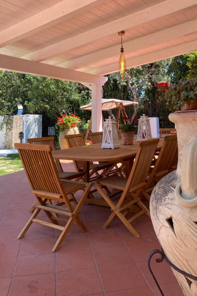 une table et des chaises en bois sous une pergola dans l'établissement Villa Vittoria, à Vieste