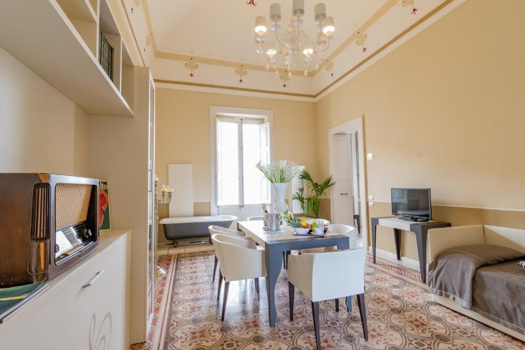 un salon avec une table, des chaises et une télévision dans l'établissement Hotel Belami, à Maglie 28 autres photos