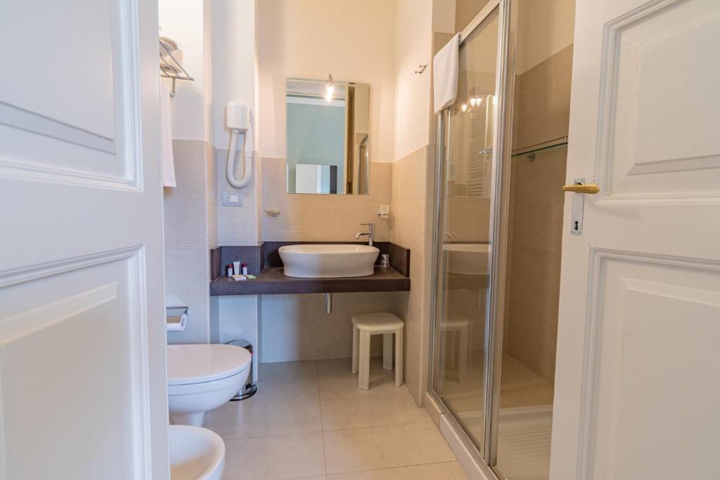 une salle de bain avec un lavabo et des toilettes dans l'établissement Hotel Belami, à Maglie