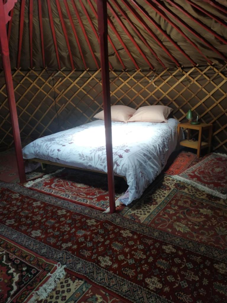 - un lit dans une yourte avec un lit sidx sidx sidx dans l'établissement Yourte rustique en permaculture, à Creysse