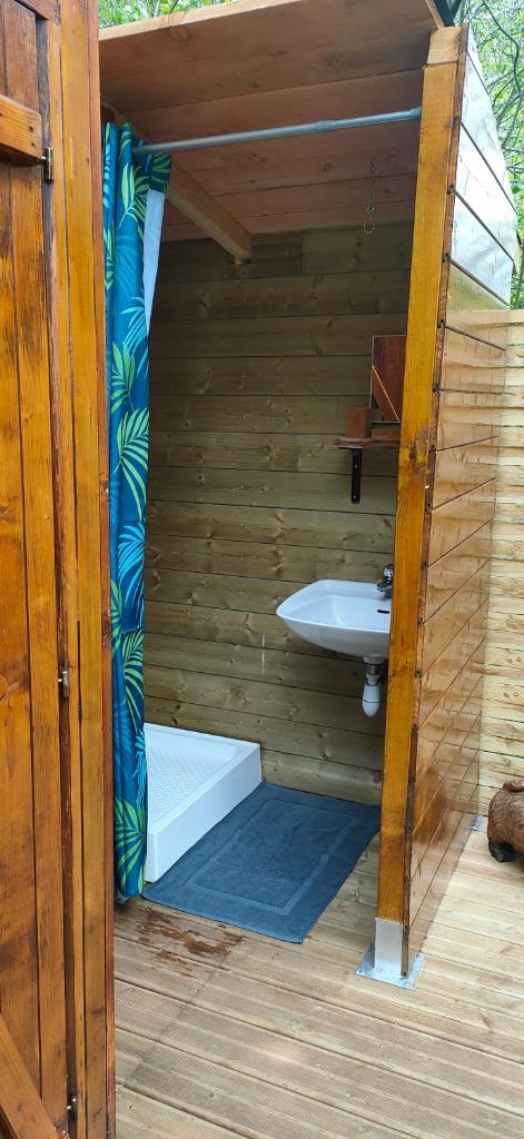 - une salle de bains avec lavabo dans une maison en bois dans l'établissement La Bulle du Cheix, à Saint-Diéry