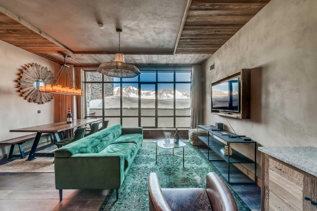 un salon avec un canapé vert et une table dans l'établissement Le Refuge de Solaise - 2551 m Altitude, à Val dʼIsère