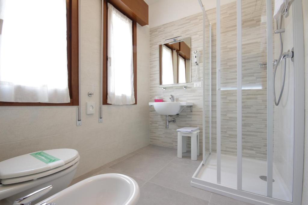 une salle de bain avec toilettes, lavabo et douche dans l'établissement Hotel Serenella, à Lido di Jesolo