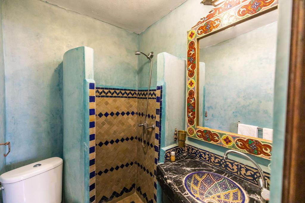 une salle de bain avec un lavabo, des toilettes et un miroir dans l'établissement Riad Jardin Chrifa, à Fès 37 autres photos