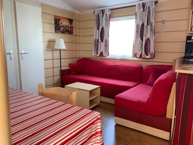 - un salon avec un canapé rouge et une fenêtre dans l'établissement Mobil Home Valras Plage, à Valras-Plage