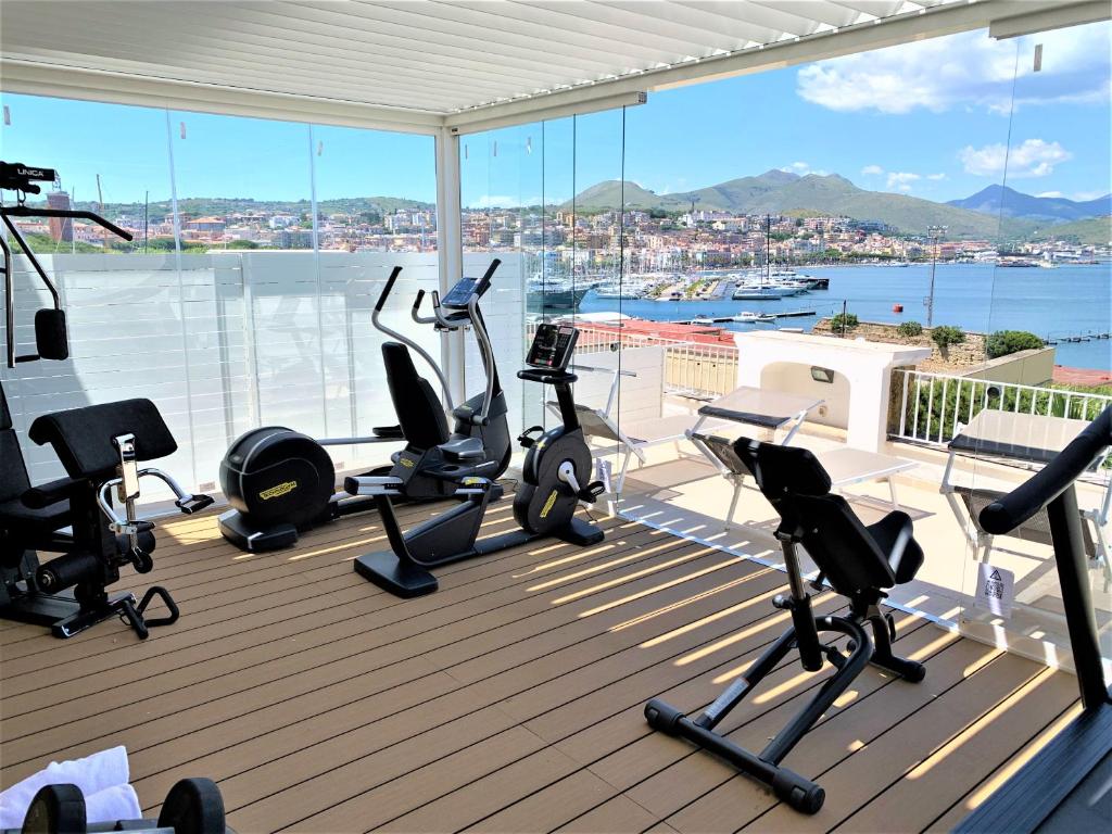 une salle de sport avec des tapis de course et des équipements d'exercice sur une terrasse dans l'établissement Hotel Gajeta, à Gaète