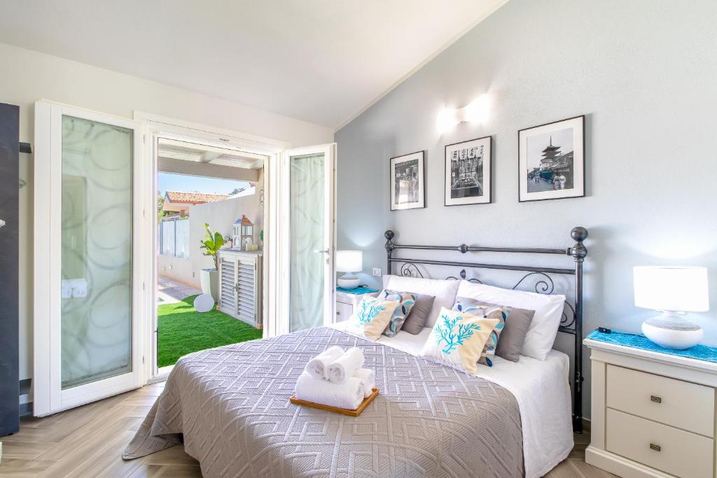 une chambre avec un lit avec une serviette dessus dans l'établissement SUNSET BAY POOL VILLA SARDINIA with private heated pool, jacuzzi, counter-current swimming, à Valledoria