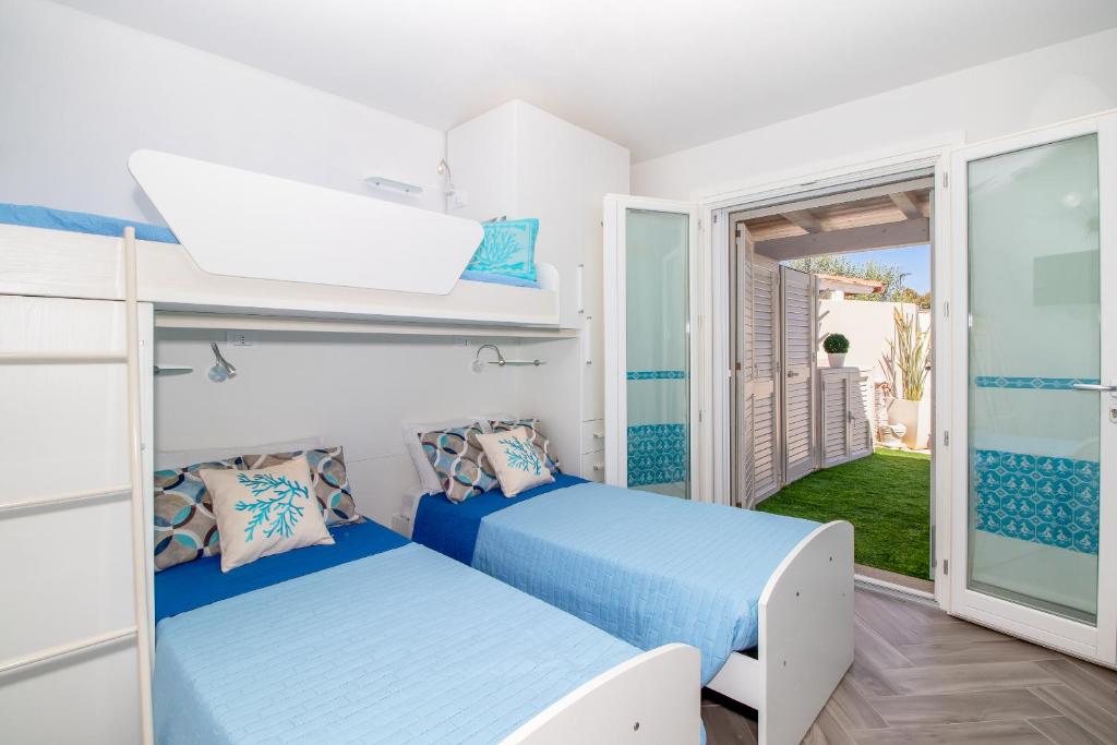 une chambre avec deux lits et un balcon dans l'établissement SUNSET BAY POOL VILLA SARDINIA with private heated pool, jacuzzi, counter-current swimming, à Valledoria 35 autres photos