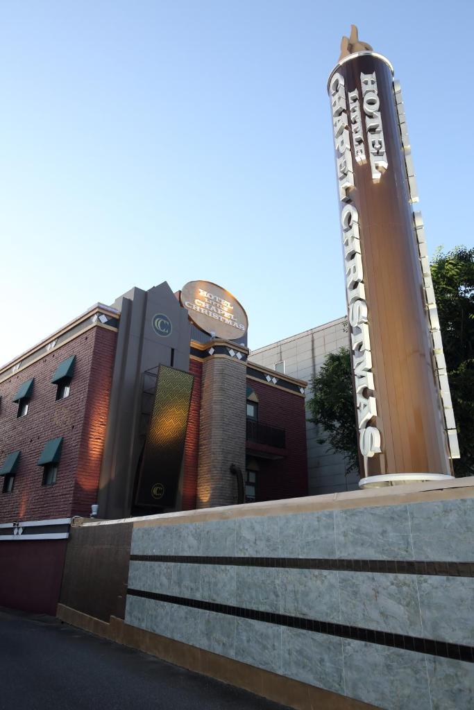 un bâtiment avec un grand panneau devant lui dans l'établissement Fukuoka Little Chapel Christmas (Love Hotel), à Fukuoka