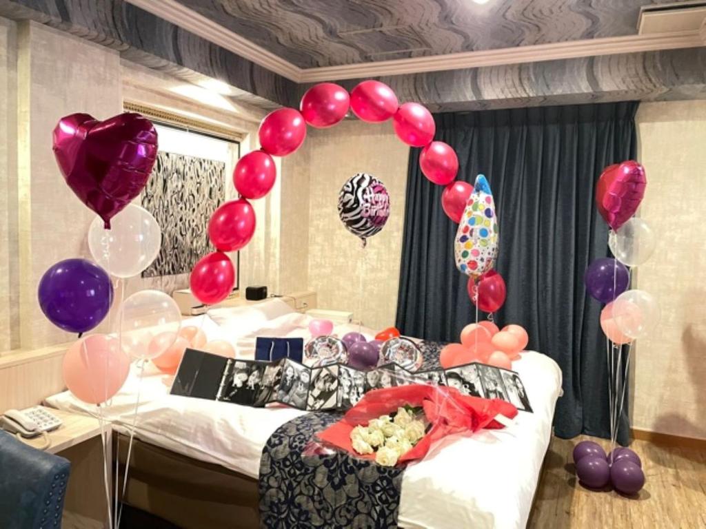 une chambre avec des ballons et un lit avec un lit dans l'établissement Fukuoka Little Chapel Christmas (Love Hotel), à Fukuoka
