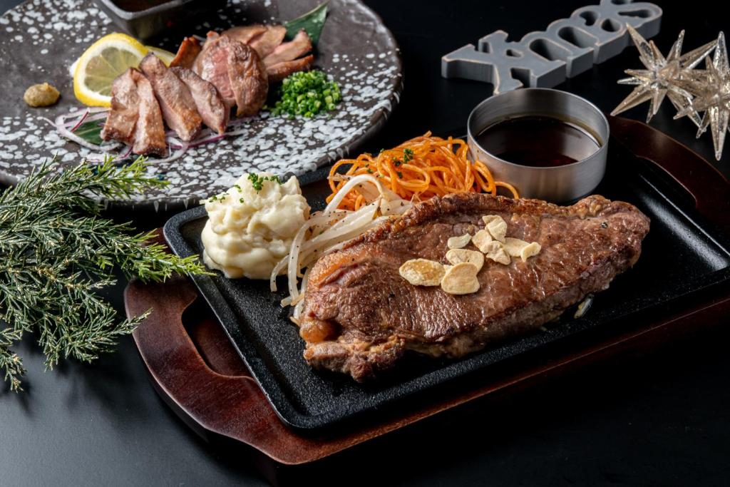 une plaque noire de nourriture avec de la viande et des légumes dans l'établissement Fukuoka Little Chapel Christmas (Love Hotel), à Fukuoka 45 autres photos