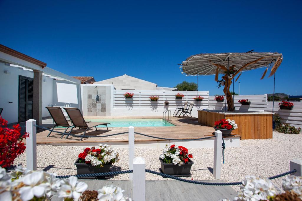 une terrasse avec une piscine et un parasol dans l'établissement Villa Elisir Luxury - Le Residenze del Mare, à Porto San Paolo