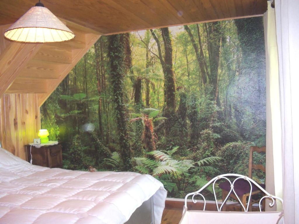 - une chambre avec une fresque murale représentant une forêt dans l'établissement Gîte Vacances en Auvergne, à Saint-Géron