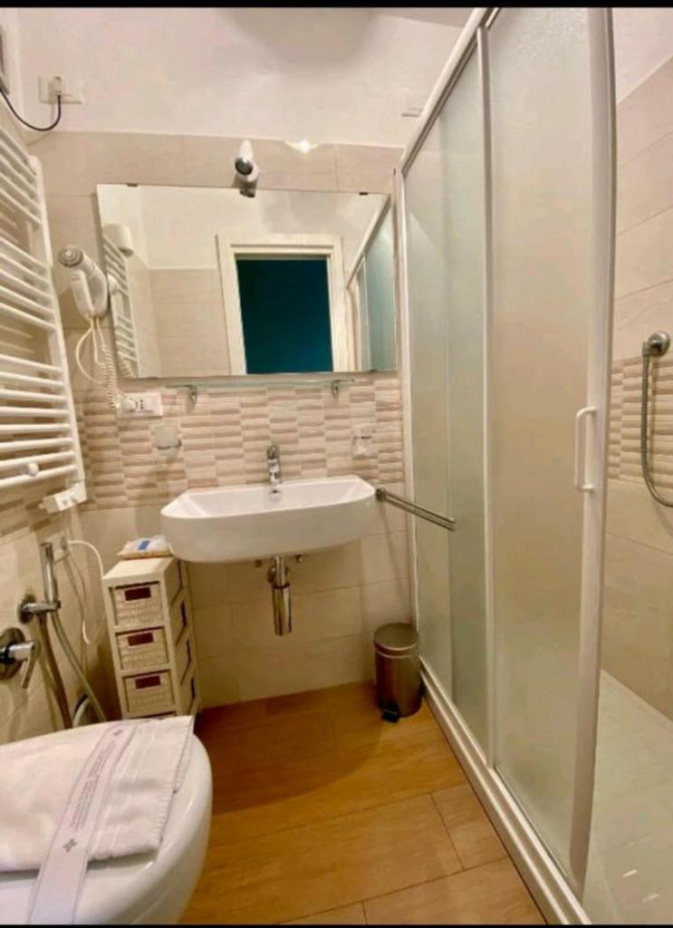 une salle de bain avec un lavabo, une douche et des toilettes dans l'établissement hotel lisà, à Viareggio