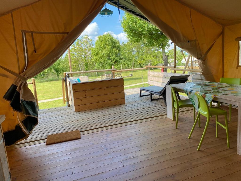 un patio avec une table et des chaises sur une terrasse dans l'établissement Glamping Place de la Famille, à Jayac