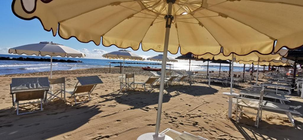 - une plage avec des chaises, des tables et un parasol dans l'établissement Hotel Diamante, à Francavilla al Mare